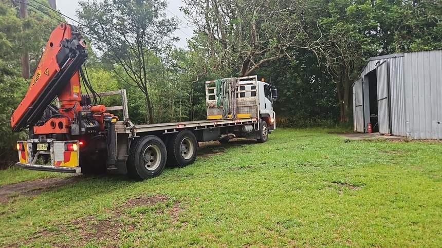 HIAB crane truck placing freight on a site with no forklift